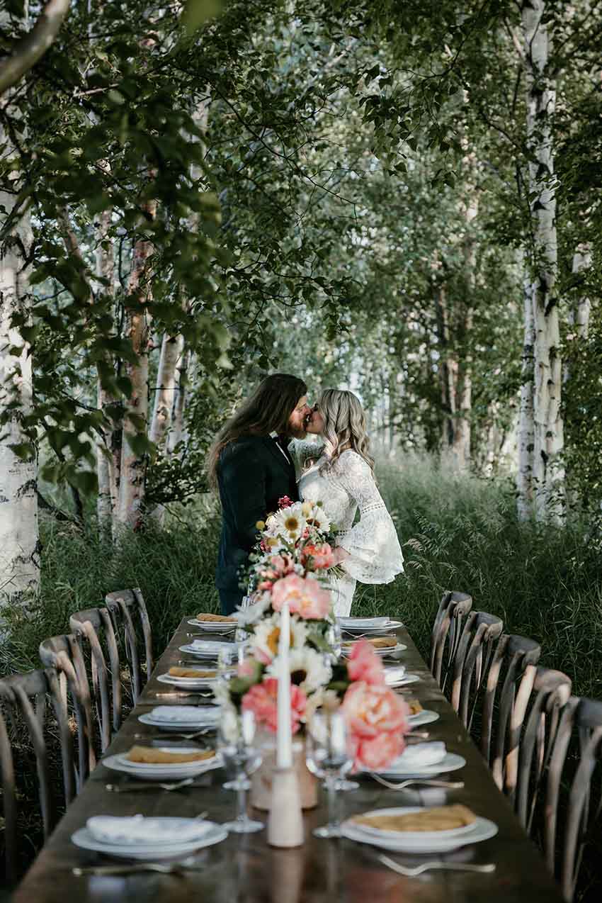 Alaska wedding couple kissing under trees